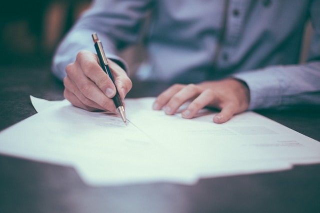 A person signing a contract.
