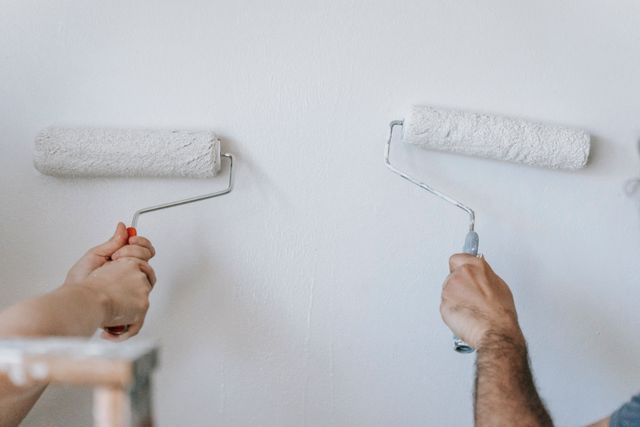 people painting a wall